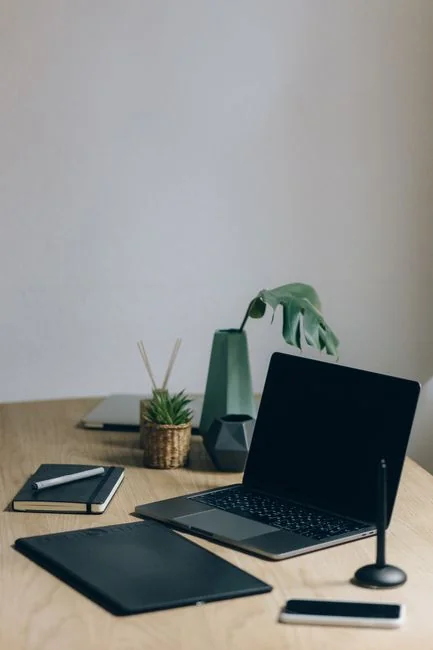 A minimalist desk setup featuring dual monitors, keyboard, mouse, and notebook for productivity.